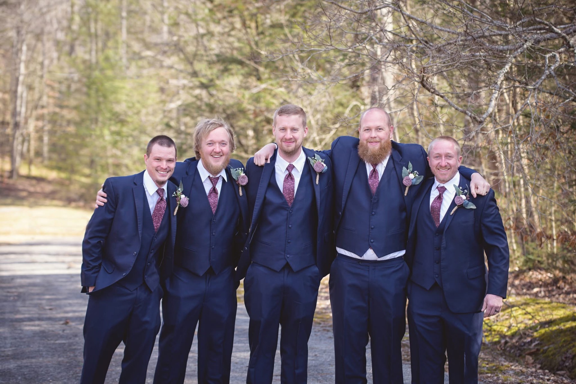 Groomsmen in navy three-piece tuxedos